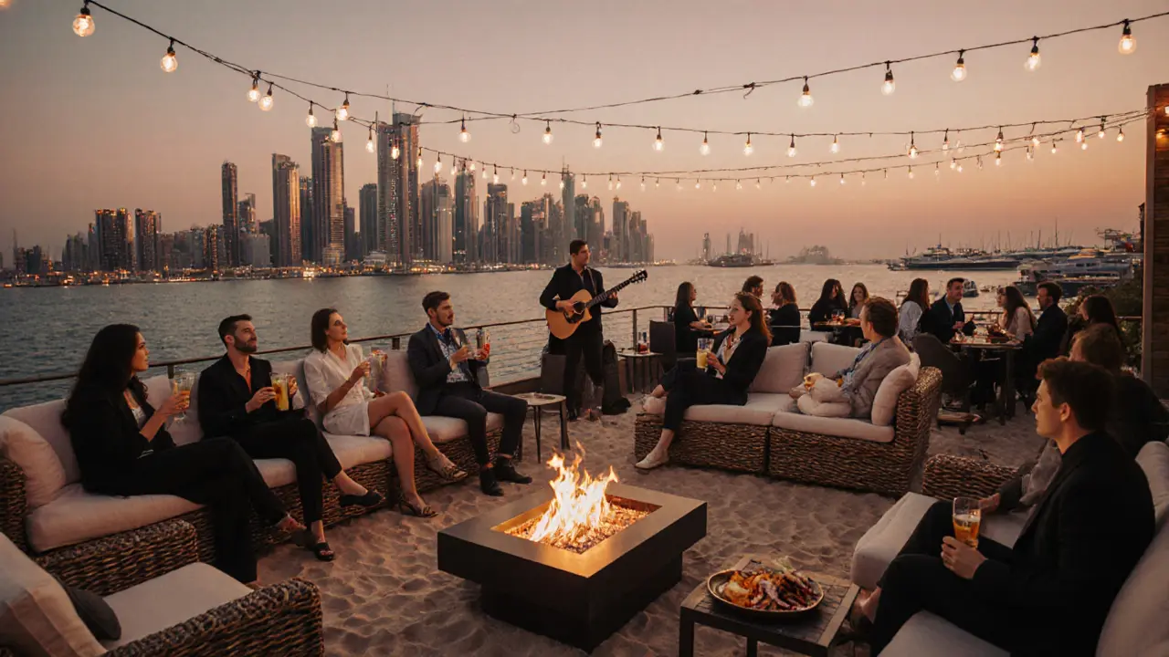 Open-air beach lounge with fire pits and cocktails overlooking Dubai Marina at dusk.